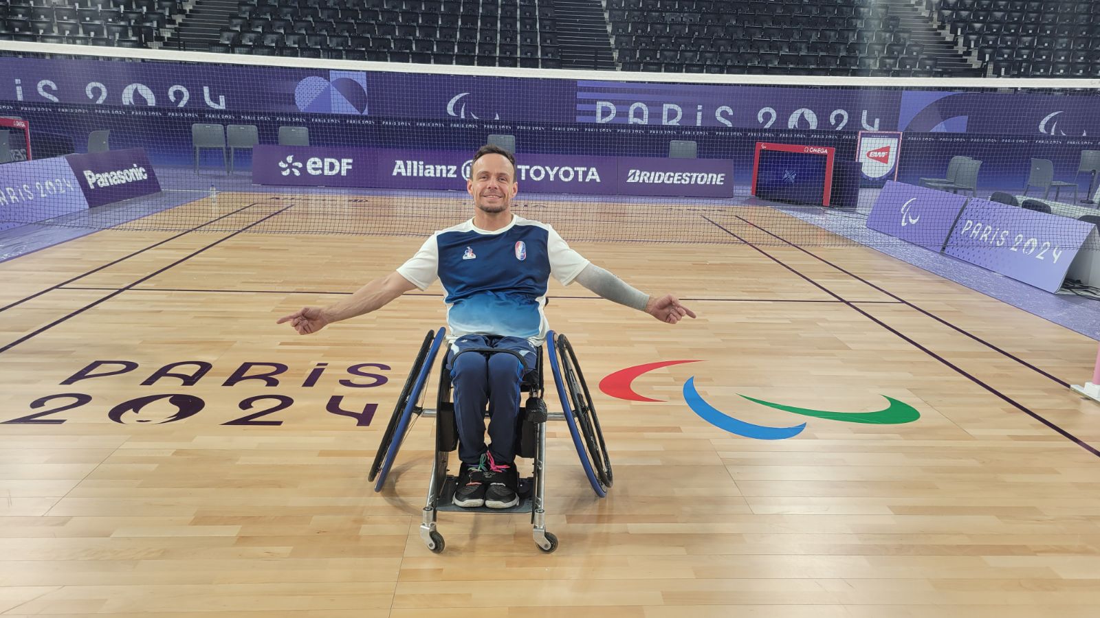 David Toupé sur le terrain de parabadminton bras ouverts fier d'être sur le terrain de Paris 2024