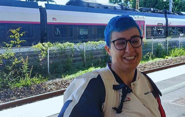 Coralie Gonzalez avec un train en arrière plan en tenu de sportive